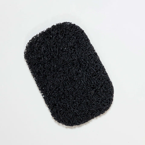 Photo of a black soap saver pad isolated on a white background.