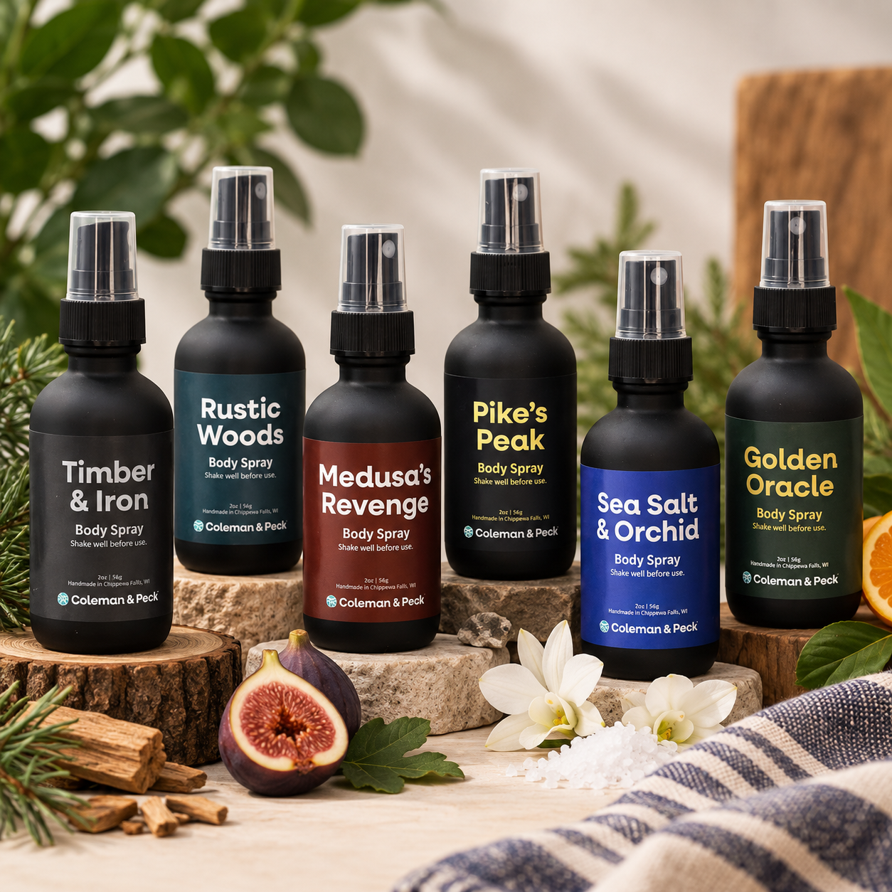 Six Ope! It’s Soap body sprays displayed with natural accents including figs, flowers, sea salt, citrus, wood, and greenery.