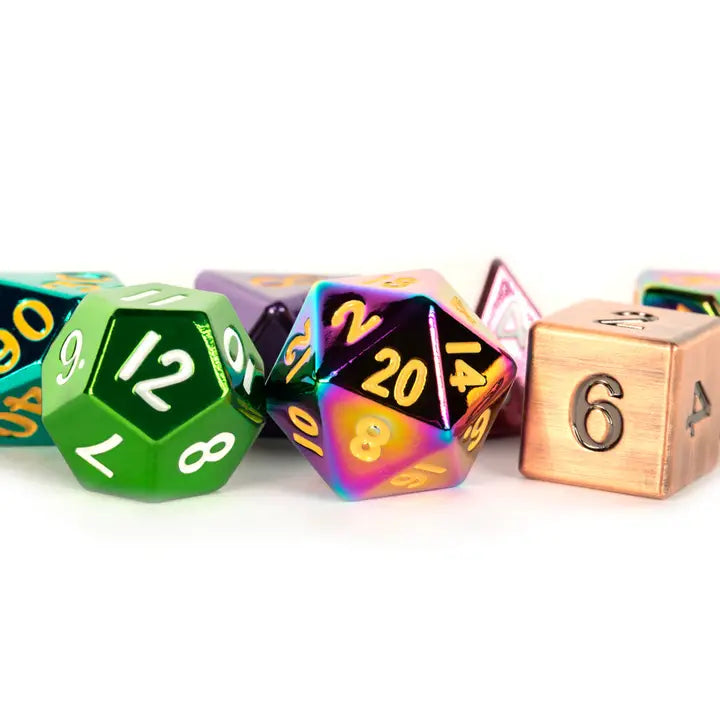 A set of polyhedral gaming dice with metallic finishes, including a green D20, a holographic rainbow D20, and a copper-colored D6, arranged on a white background.