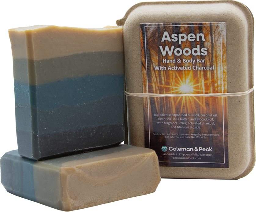 Image of three soaps stacked, one lying down, the other setting on top, next to a boxed soap.