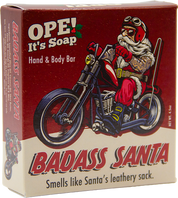 Ope! It’s Soap Badass Santa soap box featuring a tattooed Santa in biker gear riding a motorcycle against a red background with the tagline “Smells like Santa’s leathery sack.”