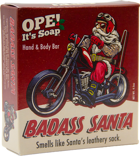 Ope! It’s Soap Badass Santa soap box featuring a tattooed Santa in biker gear riding a motorcycle against a red background with the tagline “Smells like Santa’s leathery sack.”