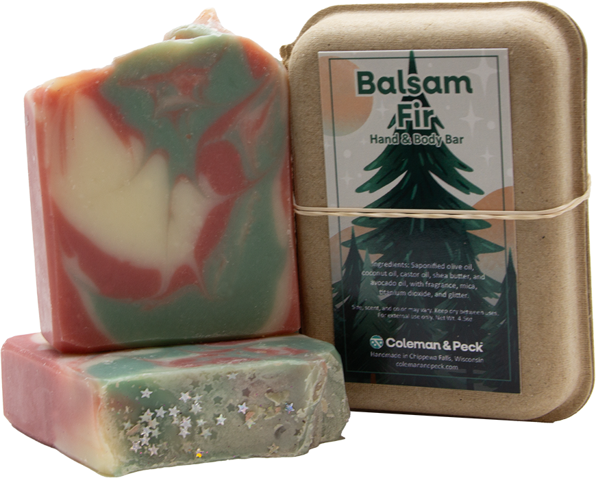 Image of three soaps stacked, one lying down, the other setting on top, next to a boxed soap.