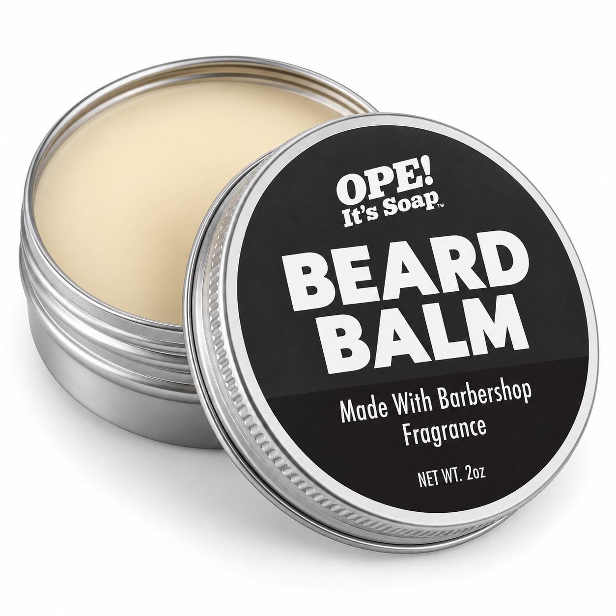An open round metal tin of OPE! It's Soap Beard Balm, showing the light beige balm inside, with the lid leaning in front displaying a black label with white text.