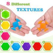 Two hands display blue and orange suction cup bath toys, with eight illustrated texture patterns below, including waves, grids, stripes, dots, stars, circles and swirls.