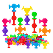 Colorful textured suction cup bath toys in red, blue, green, yellow, orange, pink and purple, with several pieces connected into tall, creative structures above a pile of individual toys on a white background.