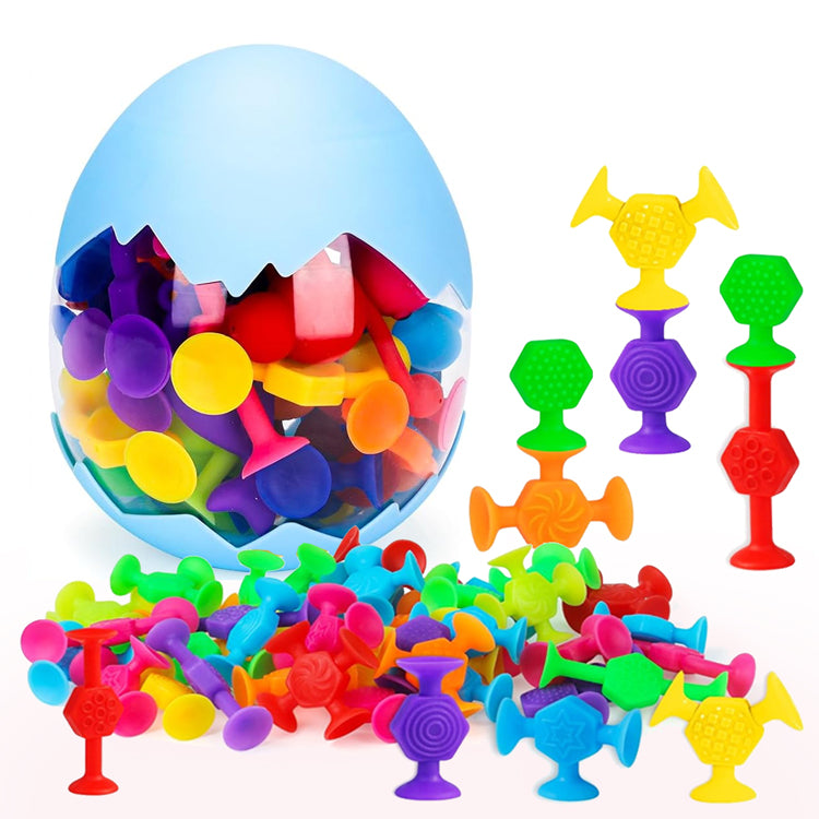 Over 40 colorful, textured suction cup toys in bright colors, including red, blue, green, yellow, orange, pink and purple. Pieces feature various shapes and patterns for stacking, connecting and sensory play, displayed alongside a blue egg-shaped storage container.
