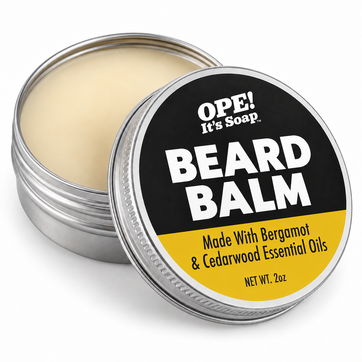 An open round metal tin of OPE! It's Soap Beard Balm, showing the pale cream balm inside, with the lid leaning in front. The lid features a black and yellow label with bold white text.