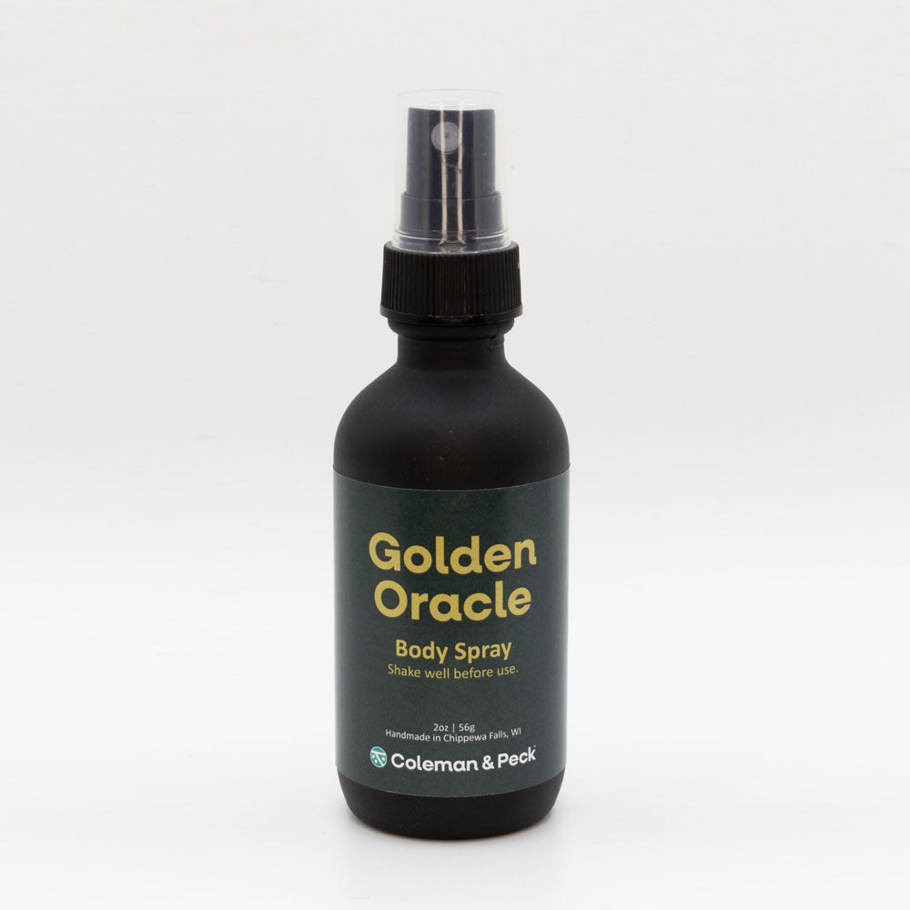 2oz black glass spray bottle with simple label. Label reads Golden Oracle Body Spray.