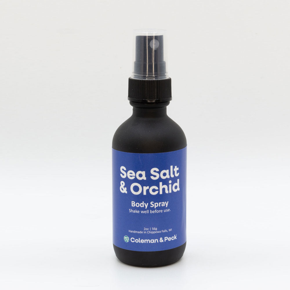 2oz black frosted spray bottle with simple label that reads Sea Salt & Orchid Body Spray.