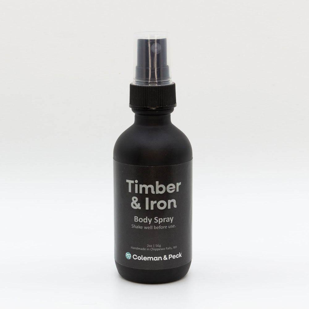 2oz frosted glass spray bottle with a simple label that reads Timber & Iron Body Spray.