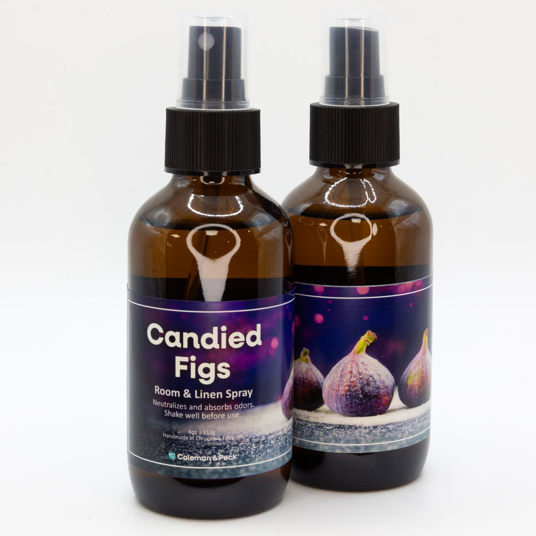 A pair of Candied Figs room & linen spray bottles, showing both sides of the label.