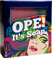 Ope! It’s Soap soap box featuring a colorful pop art portrait with bold makeup and vibrant pink, green, blue, and yellow accents, with a window revealing the pink soap inside.