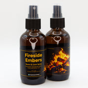 A pair of Fireside Embers room & linen spray bottles, showing both sides of the label.