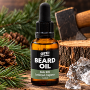 Lumberjack Beard Oil bottle surrounded by pine branches, pinecones, rustic wood, an axe, and ice accents in a rugged outdoor inspired setting.