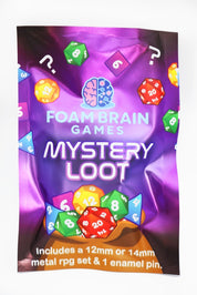 Foam Brain Games Mystery Loot blind bag surrounded by assorted metal RPG dice sets in black, rainbow, silver, copper, and multicolor finishes, along with colorful collectible enamel pins, displayed on a white background.