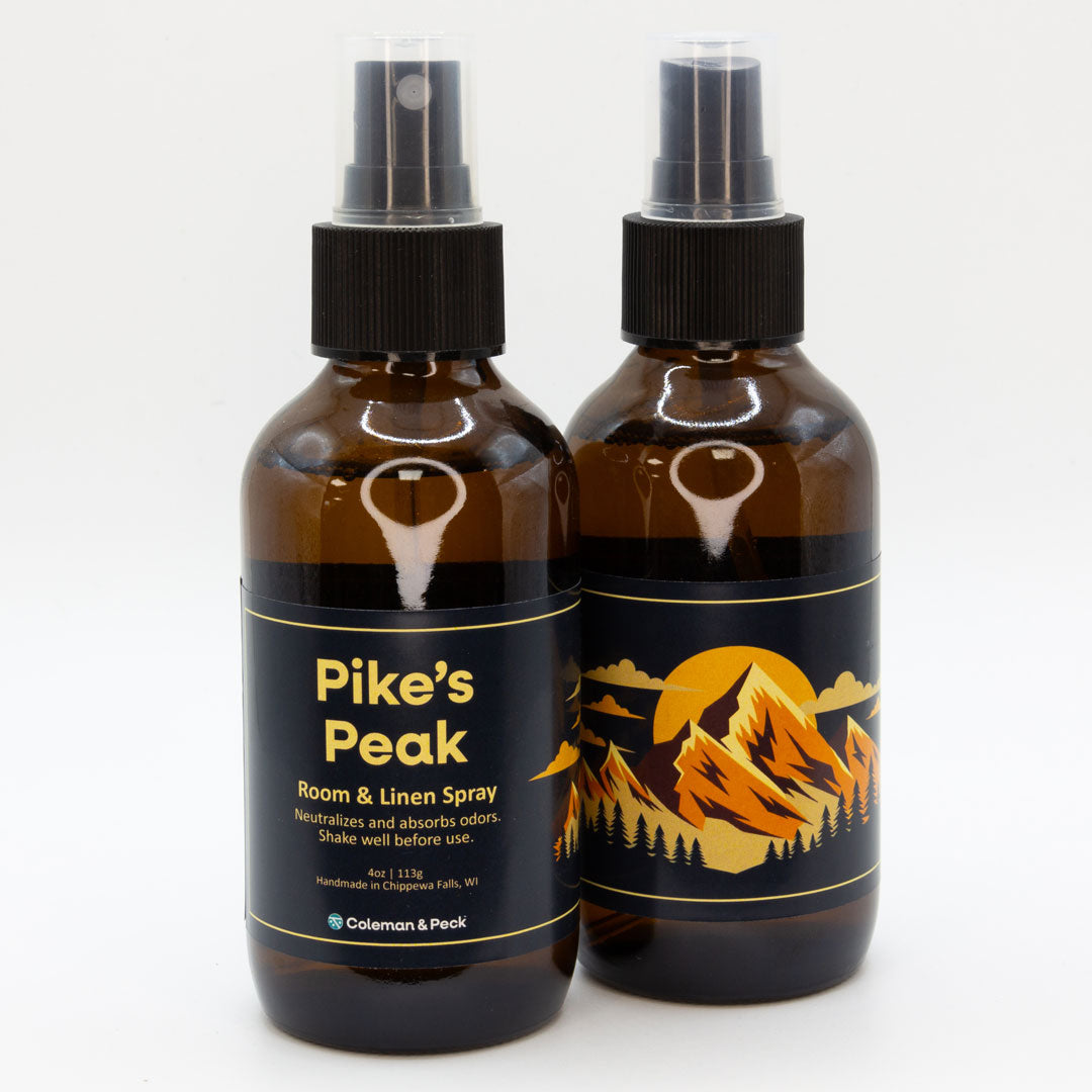 A pair of Pike's Peak room & linen spray bottles, showing both sides of the label.