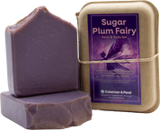 Image of three soaps stacked, one lying down, the other setting on top, next to a boxed soap.