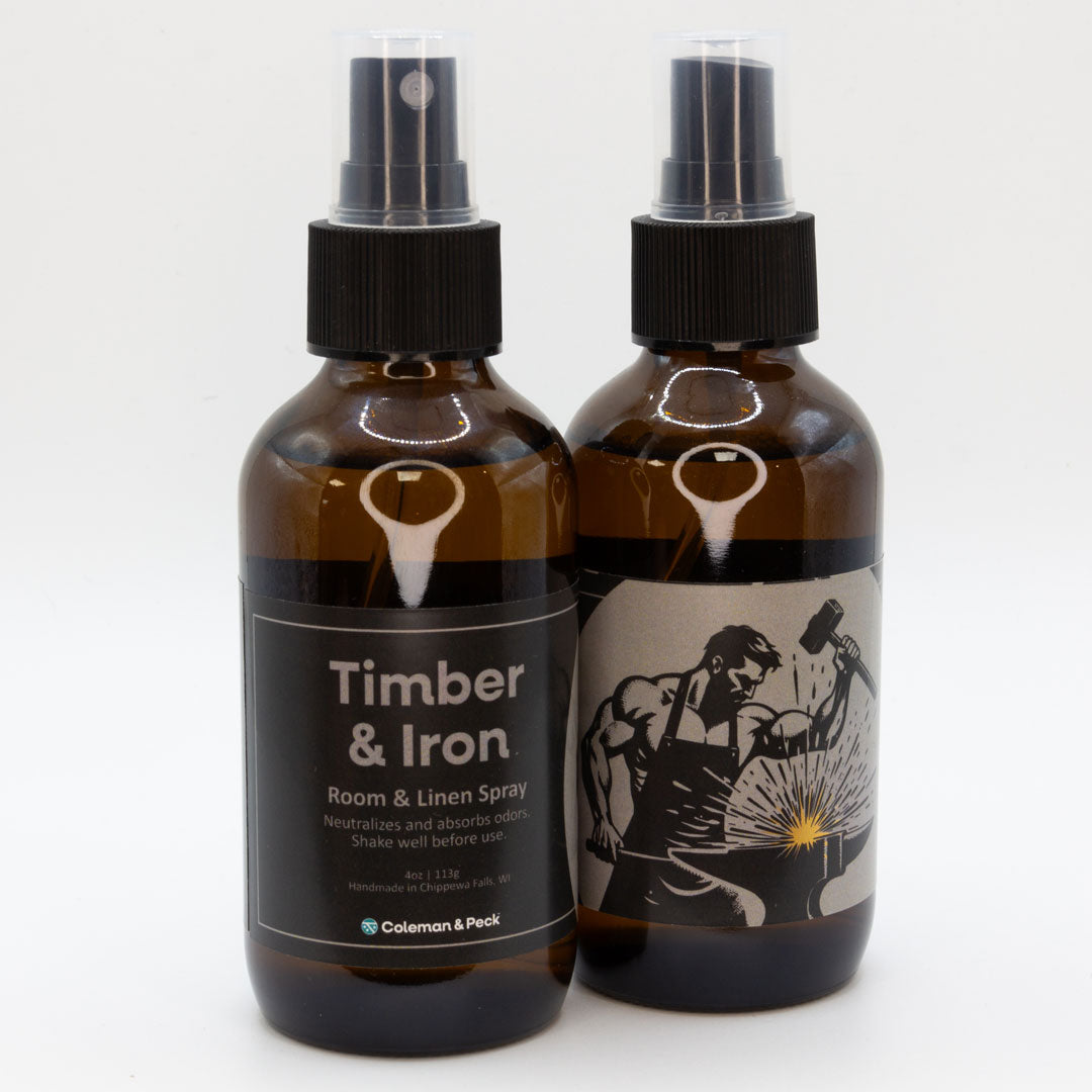 A pair of Timber & Iron room & linen spray bottles, showing both sides of the label.