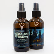 A pair of Woodland Hideaway room & linen spray bottles, showing both sides of the label.