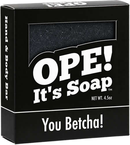 Ope! It’s Soap You Betcha! hand and body bar in black packaging with bold white lettering and a window revealing the dark, speckled soap inside.