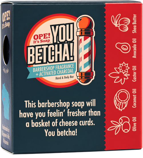 The back view of the Ope! It’s Soap You Betcha! soap box with a dark blue front, red side panel, and barber pole illustration. Visible ingredients on the red panel include Shea Butter, Avocado Oil, Castor Oil, Coconut Oil, and Olive Oil.