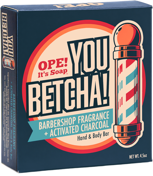 The front view of the Ope! It’s Soap You Betcha! soap box on a plain white background. The package is dark blue with large cream, red, orange, and teal graphics reading 'OPE! It's Soap YOU BETCHA! Barbershop Fragrance + Activated Charcoal' and shows a barber pole illustration.