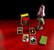 Horror Tarot cards on a red surface with a purple candle and black background
