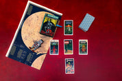 Collection of science fiction-themed books and cards on a red surface