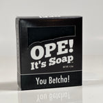 Front side of the You Betcha! soap box. Box is black with black accents.