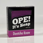 Front side of the Dontcha Know soap. Box is black with pink/purple accents.