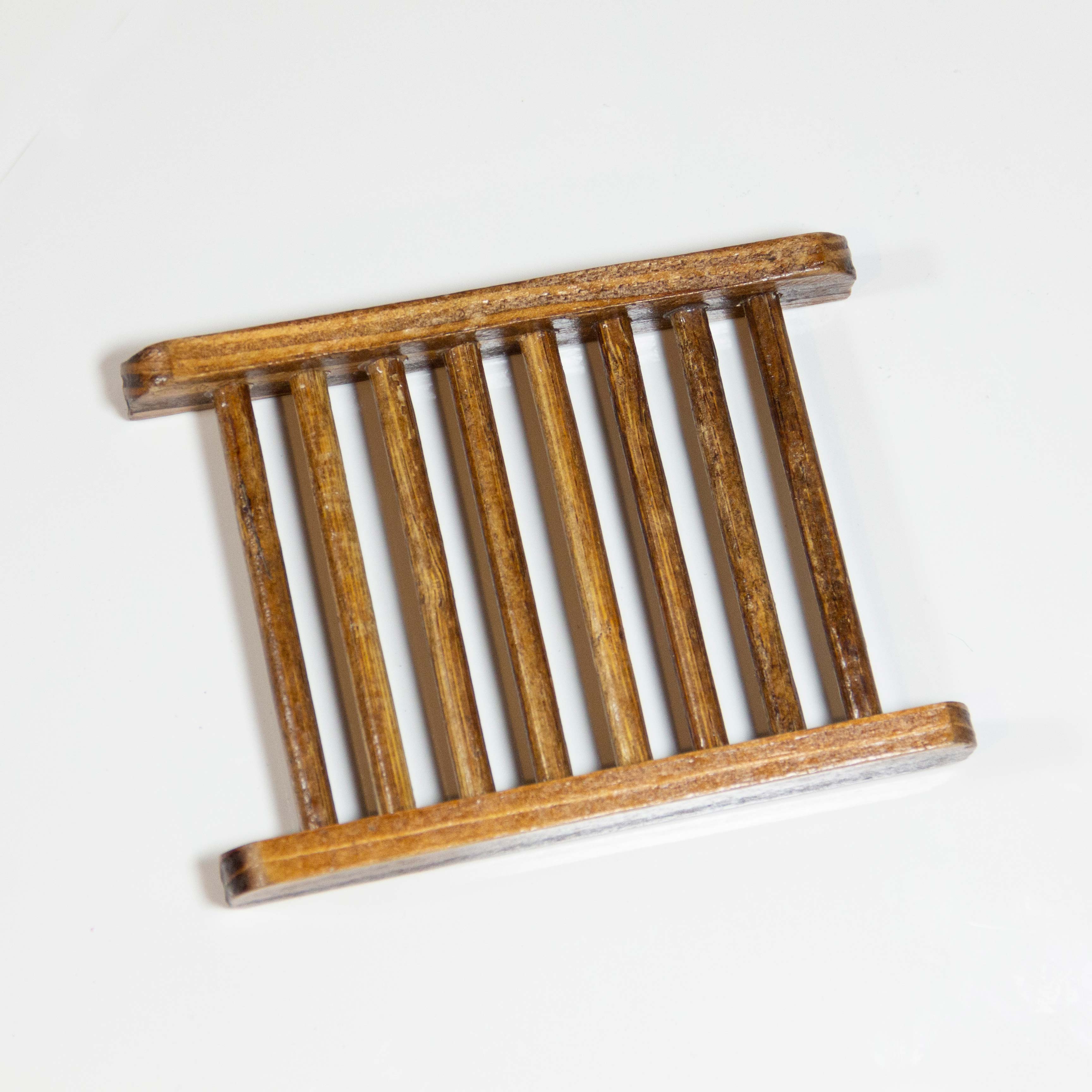 Photo of a bamboo soap holder isolated on white background.