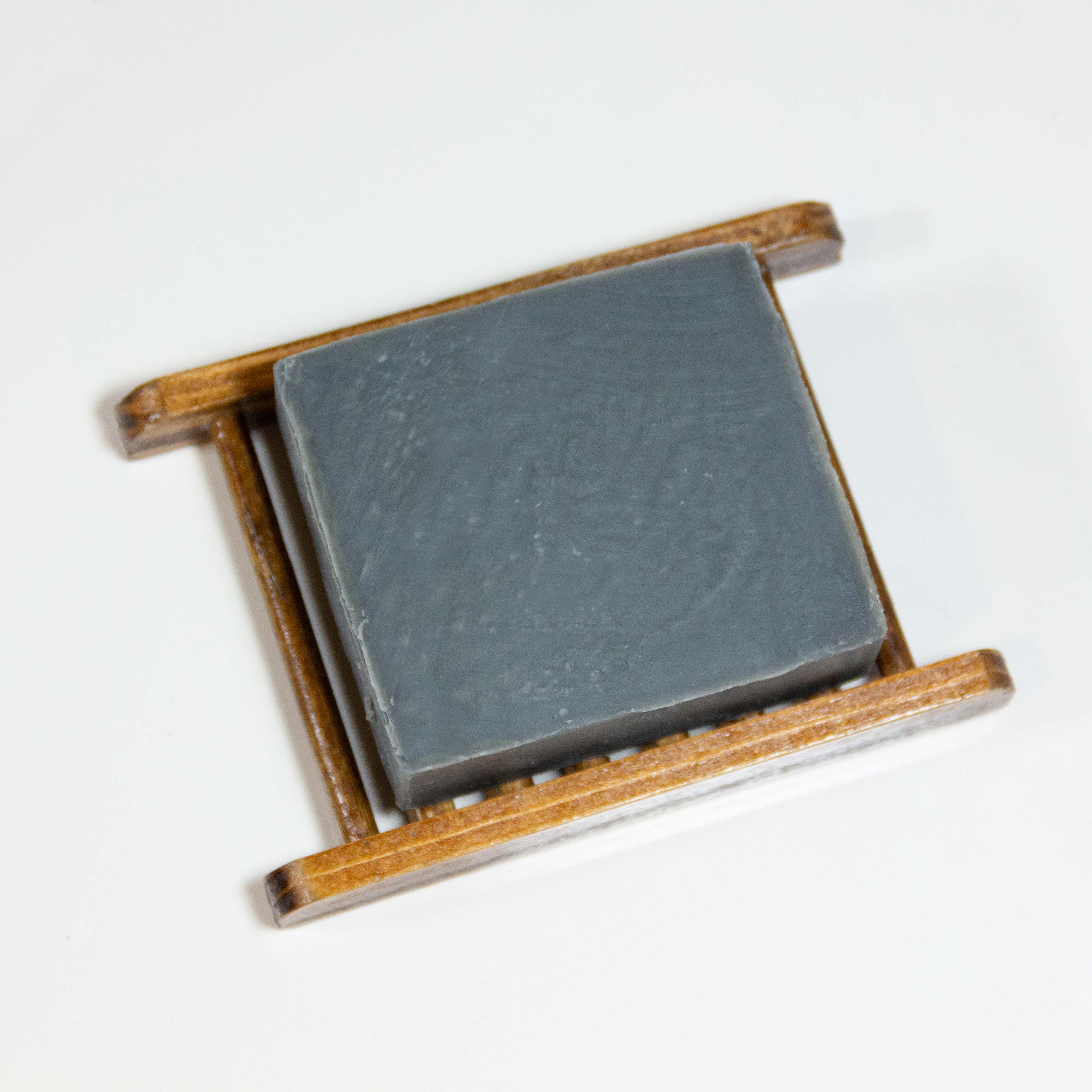 Photo of bamboo soap holder with a bar of soap on top as an example.